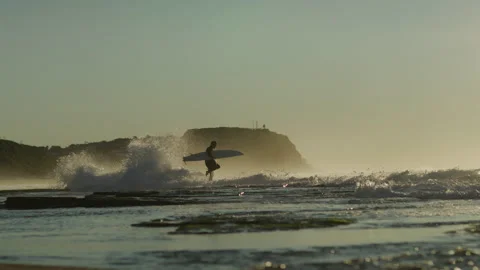 Surfer walking, Merewether Beach at dawn, rock shelf, Newcastle, NSW, Australia Stock Footage 163857499