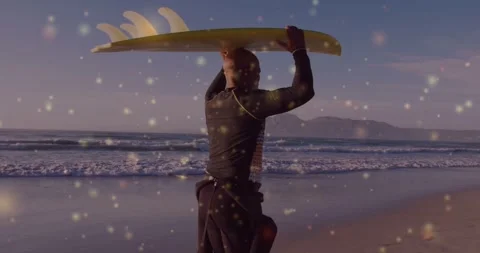 Surfer walking to ocean holding yellow board adjusting while bokeh overlaying 스톡 동영상 333901355