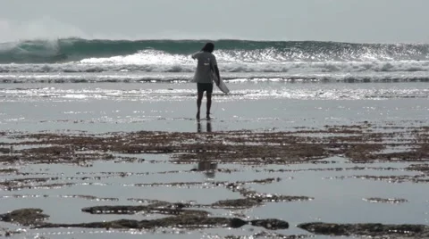Surfer Walking on the Reefs at Low Tide Stock Footage 67533476
