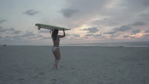 Surfer walking towards ocean with board on head Video stock 140360235