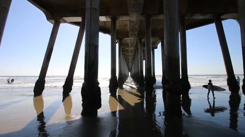 Surfer walking under bridge Vídeos de archivo 166805495