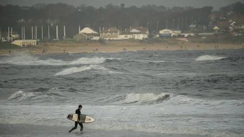 Surfer walking into the waves at Roker b... | Stock Video | Pond5