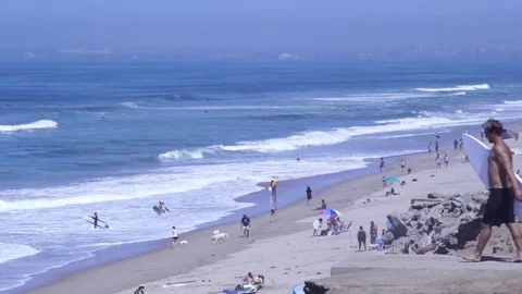 Surfer walks out on a bluff over looking the beach to check Stock Footage 71112919
