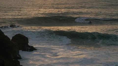 Surfer with waves crashing during sunset Stock Footage 304003239