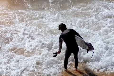 Surfer in wetsuit on the beach. Foto stock