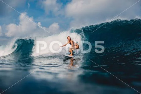 Surfer woman at surfboard on barrel wave. Sporty woman in ocean during surfin Stock Photos