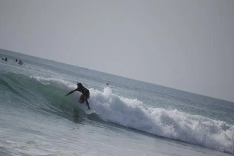 Surfers in action on the waves at Dreamland beach Stock Photos