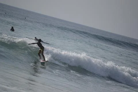 Surfers in action on the waves at Dreamland beach Stock Photos