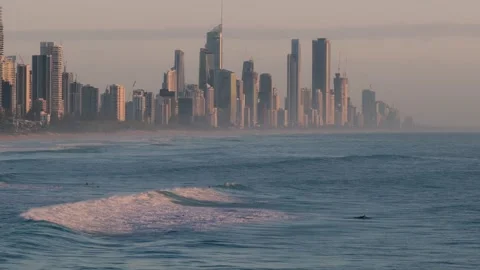 Surfers And Rolling Waves Backdropped By Surfers Paradise Skyline On Gold Видео 336244512