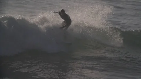 Surfers catch waves at sunset. Stock Footage 82330373