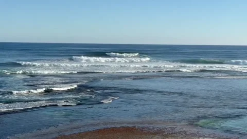 Surfers Catching Ocean Waves Along Rocky Coastline Stock Footage 339584105
