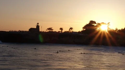 Surfers catching a wave at sunset Stock Footage 85918443