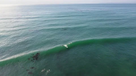 Surfers Catching Waves Along the Coast, Aerial Footage Video stock 150724340