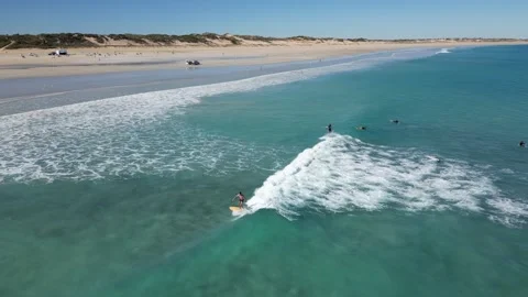 Surfers Catching Waves Breaking Over White Sand Cable Beach Broome WA Stock Footage 276430533