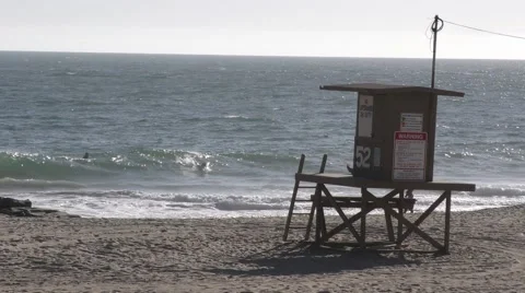 Surfers catching waves including getting a barrel by a life guard stand on a Stock Footage 67617083