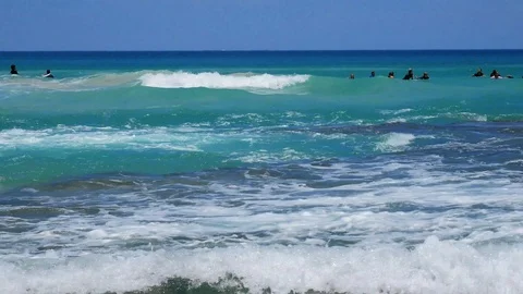 Surfers catching waves low angle summertime tourism Stock Footage 121198871
