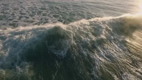 SURFERS COUPLE TAKING THE WAVES AT SUNSET Stock Footage 132953253