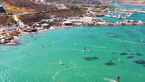 Surfers doing windsurfing at Turkey's world famous Cesme Alacati Beach Stock Footage 240853513