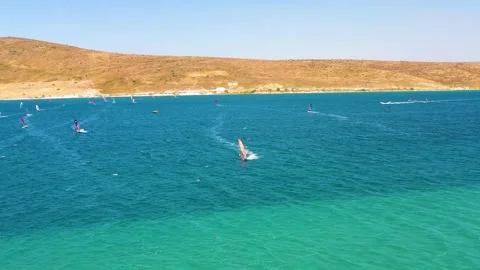 Surfers doing windsurfing at Turkey's world famous Cesme Alacati Beach Stock Footage 240853560