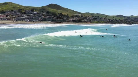 Surfers enjoy the waves in the Pacific Ocean, Cayucos, California. Stock Footage 67341844