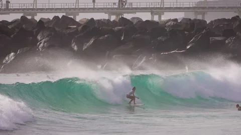 Surfers enjoying large waves during a morning surfing session at Duranbah Beach. Stockbeeldmateriaal 331385344