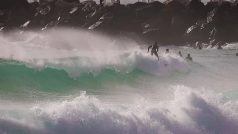 Surfers enjoying large waves during a morning surfing session at Duranbah Beach. Stockbeeldmateriaal 331385790