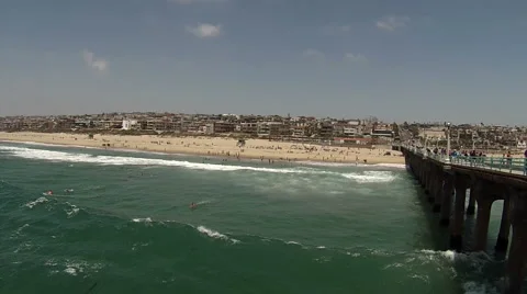 Surfers get exercise on a sunny day as they surf next to the Manhattan Beach Stock Footage 68501170