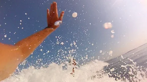 Surfers giving a high-five greeting while surfing, slow motion. Stock Footage