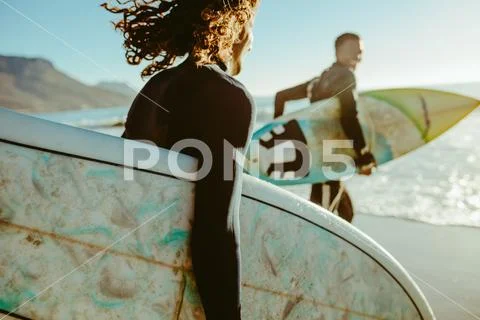 Surfers going for surfing in the sea Stock Photos