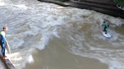 Surfers on a man-made wave  on the Eisbach river Stock Footage 66610275