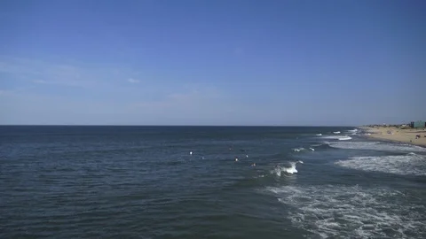 Surfers out in the waves on the beach Stock Footage 90500707