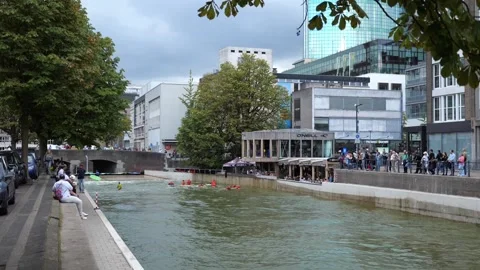 Surfers ride artificial waves in urban pool near café terrace Vidéo 319909607