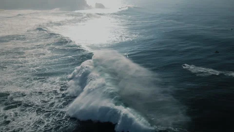 Surfers ride massive waves at Nazare Portugal's breathtaking sea Stock Footage 321504028