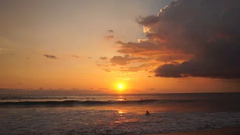 Surfers ride at orange sunset over Indian Ocean Stock Footage 108791477