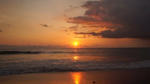 Surfers ride at orange sunset over Indian Ocean Stock Footage 108793924