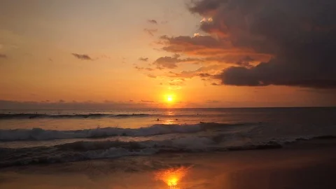 Surfers ride at orange sunset over Indian Ocean Stock Footage 108794634