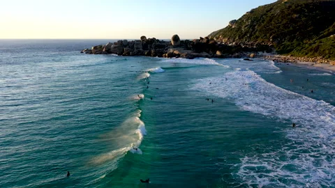 Surfers ride waves on the rocky Cape coastline Stock Footage 340557433