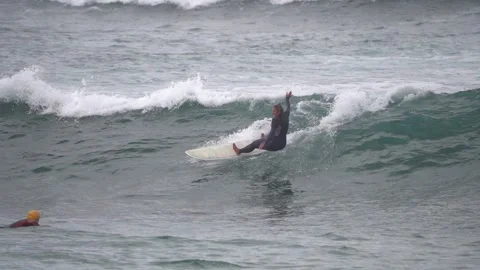 Surfers ride waves in slow motion at Las Canteras Beach Video stock 233253903