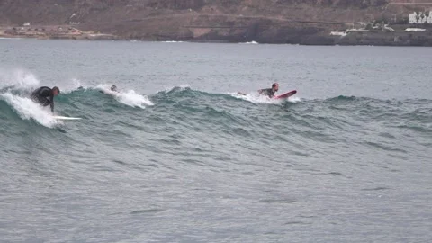 Surfers ride waves in slow motion at Las Canteras Beach Video stock 233254384