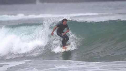 Surfers ride waves in slow motion at Las Canteras Beach Video stock 233254405