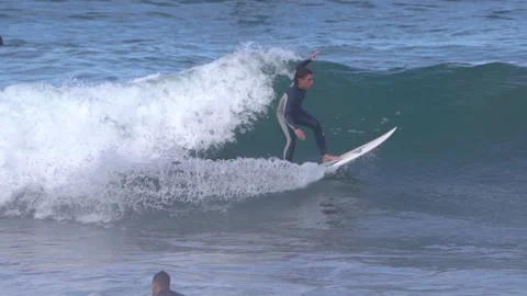 Surfers ride waves in slow motion at Las Canteras Beach Video stock 233254534