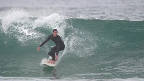 Surfers ride waves in slow motion at Las Canteras Beach Stock-Footage 233256895