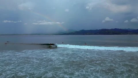 Surfers riding ocean wave under vibrant rainbow. Perfect aerial view drone Stock Footage 340199298