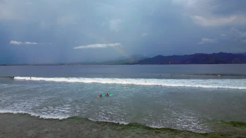 Surfers riding ocean wave under vibrant rainbow. Magic aerial view drone Stock Footage 340199807