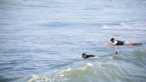 Surfers riding waves at the seashore in Spain Stock Footage 114144652