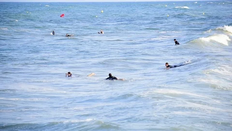 Surfers riding waves at the seashore in Spain Stock Footage 114155695
