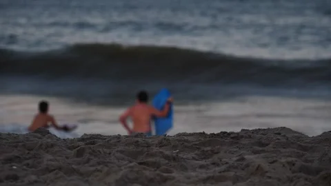 Surfers riding waves at sunset on the beach Video stock 281818958