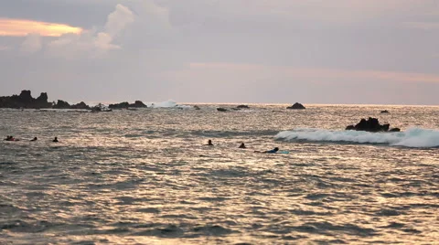 Surfers at sunset in Easter Island, Chile Stock Footage 64872349