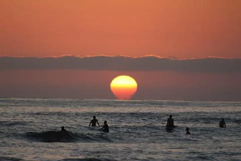 Surfers in the Sunset over the Pacific Ocean 스톡 사진