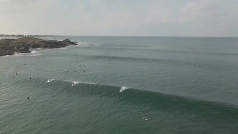Surfers surf on waves with surfboards at the Pointe de la Torche in Brittany Stock Footage 212341714